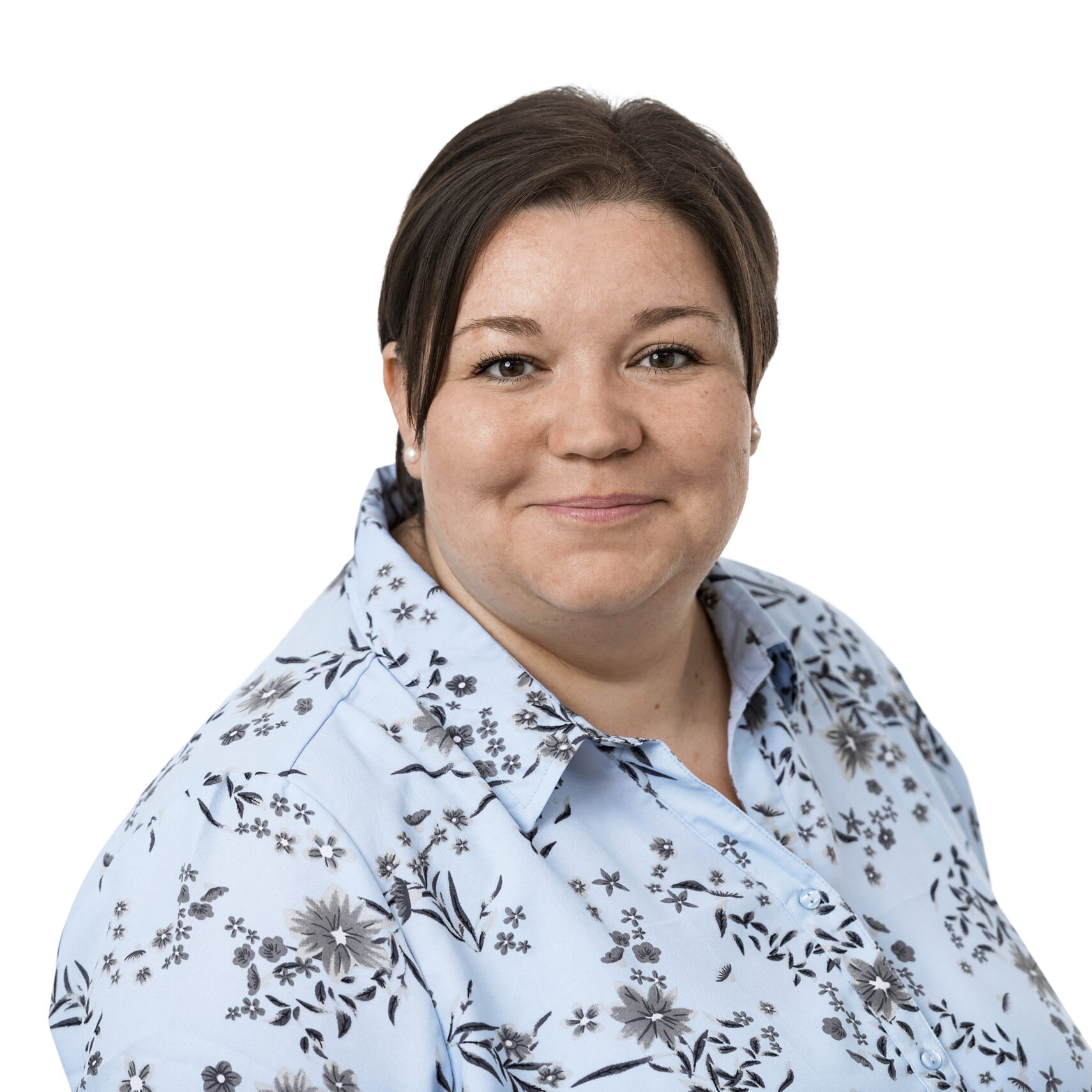 Eine Frau mit kurzen braunen Haaren, die ein hellblaues Hemd mit schwarzem und grauem Blumenmuster trägt, lächelt vor einem schlichten weißen Hintergrund in die Kamera - perfekt, um Ihr Team des Dienstleistungszentrums zu repräsentieren.