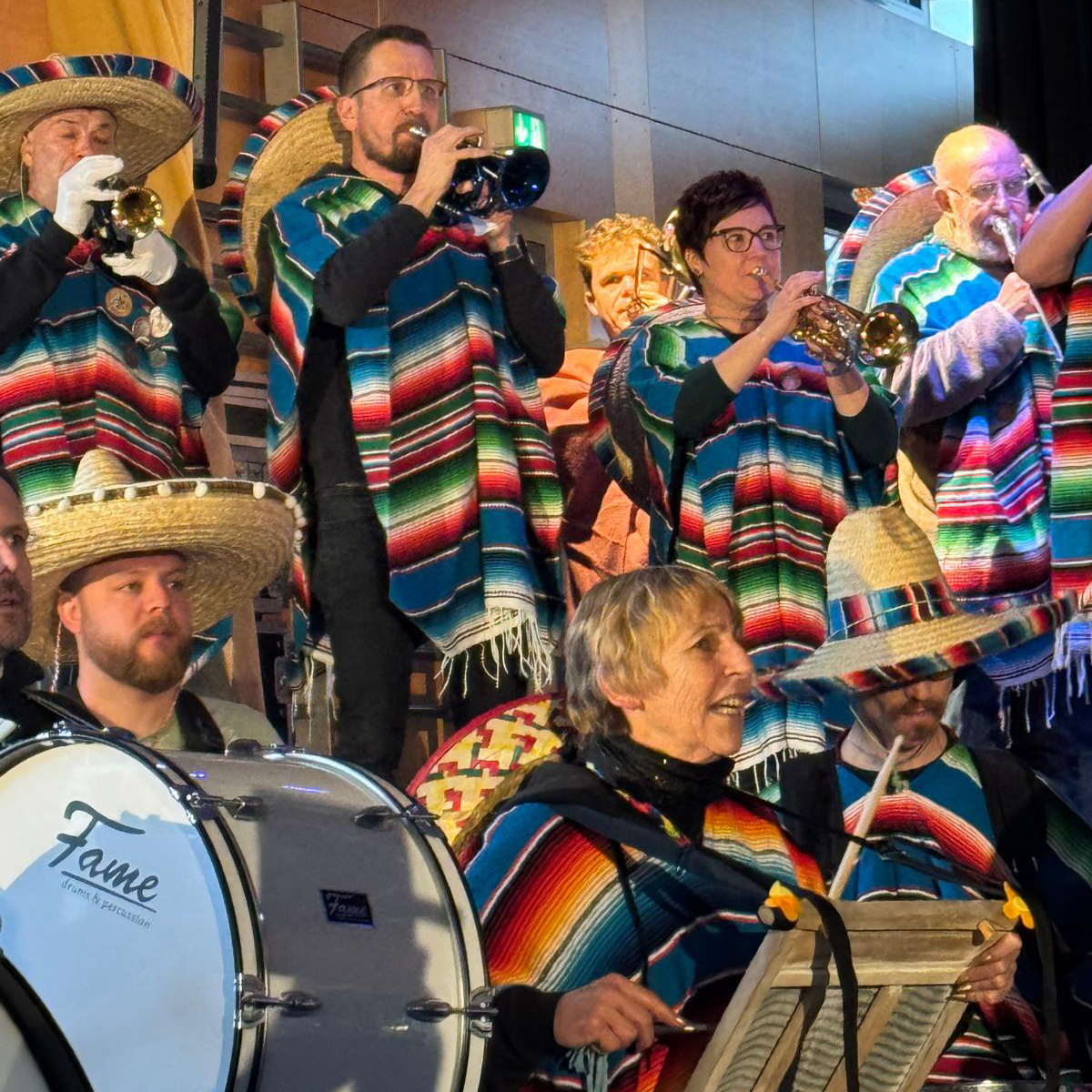 Im Bischof Sproll Haus spielt während des Waldstetter Faschings eine Gruppe von Musikern in bunten Ponchos und Sombreros auf Blechblasinstrumenten und Trommeln im Innenraum, beleuchtet von der Bühnenbeleuchtung. Im Bischof Sproll Haus spielt während des Waldstetter Faschings eine Gruppe von Musikern in bunten Ponchos und Sombreros auf Blechblasinstrumenten und Trommeln im Innenraum, beleuchtet von der Bühnenbeleuchtung.